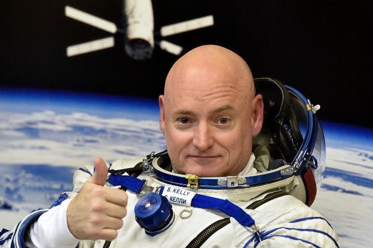 US astronaut Scott Kelly gives the thumbs up as his space suit is tested at the Russian-leased Baikonur cosmodrome, prior to blasting off to the International Space Station (ISS), on March 27, 2015