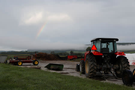 A tractor sits at a farm with a rainbow in the distance outside Cortland, New York, U.S., August 23, 2018. Picture taken August 23, 2018. REUTERS/Shannon Stapleton