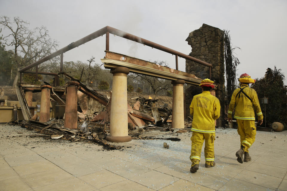 <p>A pair of Napa County firemen walk through the remains of the Signorello Estate winery Tuesday, Oct. 10, 2017, in Napa, Calif. (Photo: Eric Risberg/AP) </p>