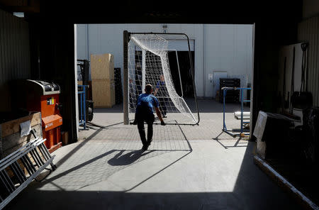 Workers hold a goal at Interplastic, a Polish manufacturing company who are supplying the football goalposts for the 2018 World Cup finals in Russia, in Chwaszczyno, Poland, May 16, 2018. Picture taken May 16, 2018. REUTERS/Kacper Pempel