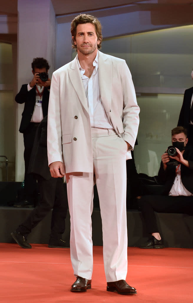 Jake Gyllenhaal in an all cream-colored tailored suit with brown dress shoes on the red carpet for "The Lost Daughter"