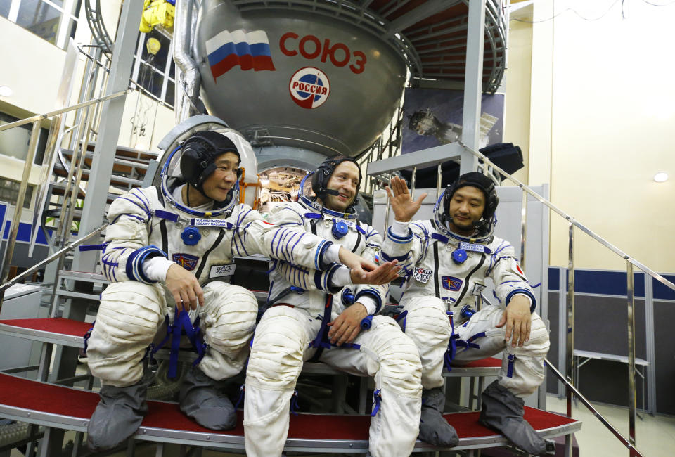 Roscosmos cosmonaut Alexander Misurkin, center, and space flight participants Yusaku Maezawa, left, and Yozo Hirano pose for a picture during a training session ahead of the expedition to the International Space Station at the Gagarin Cosmonauts' Training Center in Star City outside Moscow, Russia, Thursday, Oct. 14, 2021. A Japanese fashion tycoon who's booked a SpaceX ride to the moon is going to try out the International Space Station first. Yusaku Maezawa announced that he's bought two seats on a Russian Soyuz capsule. He'll blast off in December on the 12-day mission with his production assistant and a professional cosmonaut. (Shamil Zhumatov/Pool Photo via AP)