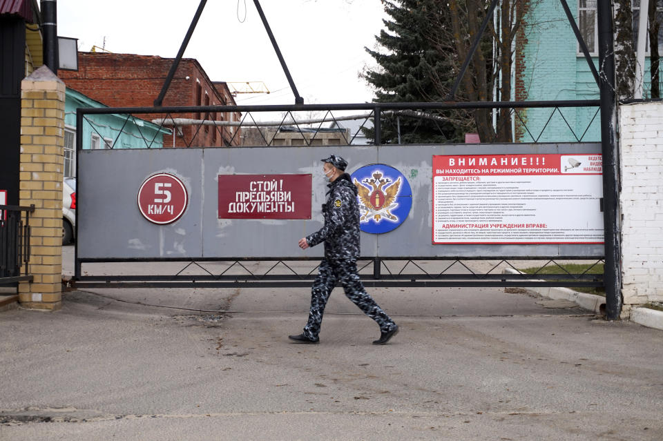 Security staff walk at the gate of the penal colony where a hospital for convicts located in Vladimir, a city 180 kilometers (110 miles) east of Moscow, Russia, Tuesday, April 20, 2021. Several doctors have been prevented from seeing Russian opposition leader Alexei Navalny at a prison hospital after his three-week hunger strike. Prosecutors, meanwhile, detailed a sweeping, new case against his organization. Navalny was transferred Sunday from a penal colony east of Moscow to a prison hospital in Vladimir, east of the capital, and his lawyers and associates have said that his condition has dramatically worsened. Reports about his rapidly deteriorating health has drawn international outrage. (AP Photo/Kirill Zarubin)