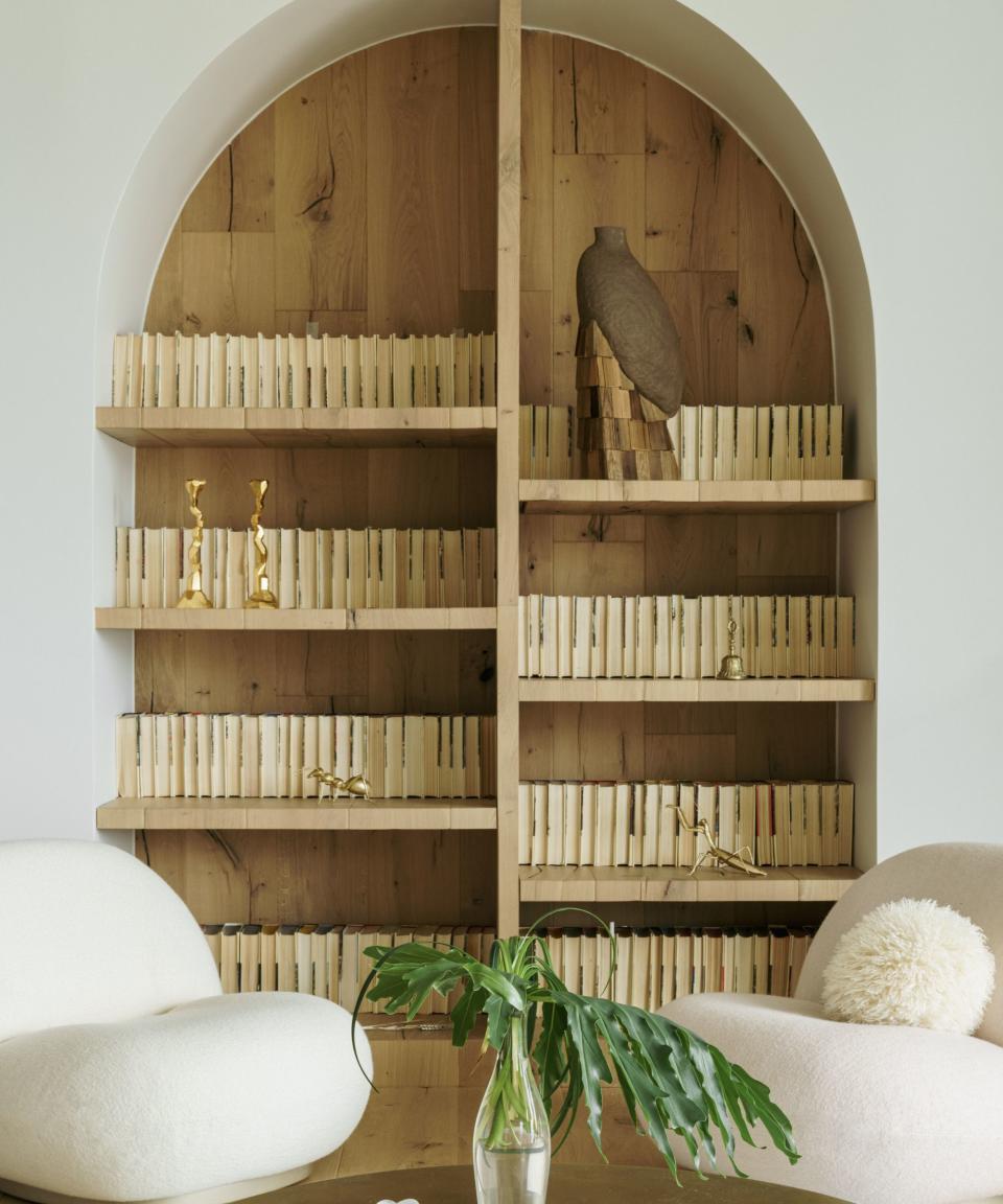 living room with arched shelves and white chairs