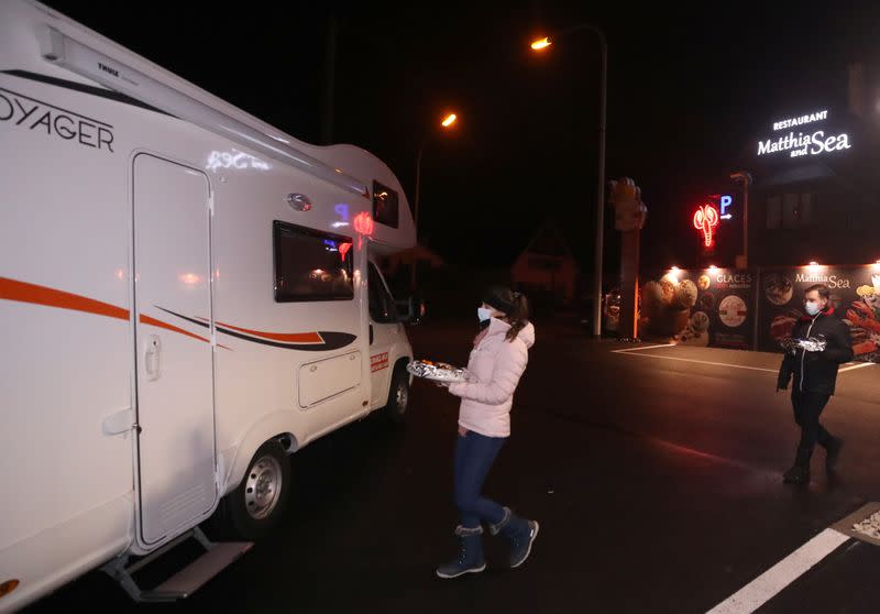 Customers enjoy dinner sitting inside a motorhome camper parked at the Belgian restaurant Matthias And Sea in Tarcienne