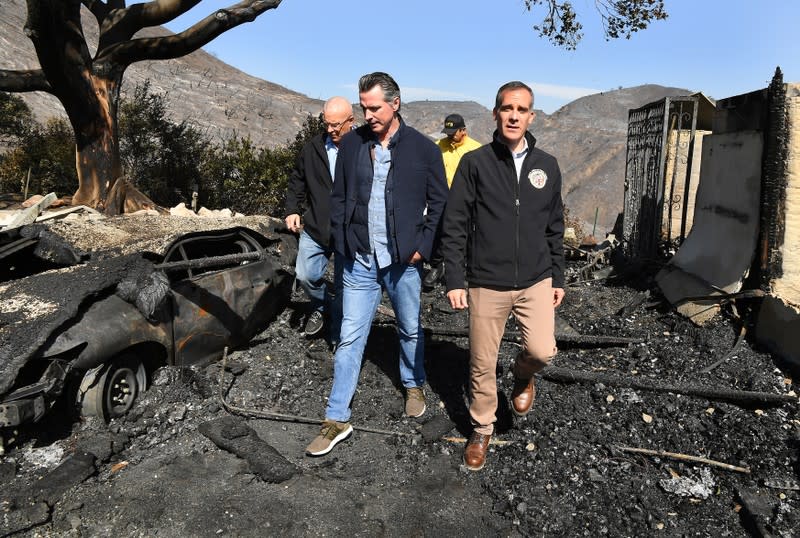 From left, L.A. Mayor Eric Garcetti (L) and and California Governor Gavin Newsom view a burned and home along Tigertail Road in Brentwood