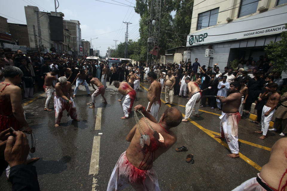 Shiite Muslims flagellate themselves with knifes on chains during a procession to mark Ashoura, in Peshawar, Pakistan, Friday, July 28, 2023. Ashoura is the Shiite Muslim commemoration marking the death of Hussein, the grandson of the Prophet Muhammad, at the Battle of Karbala in present-day Iraq in the 7th century. (AP Photo/Mohammad Sajjad)