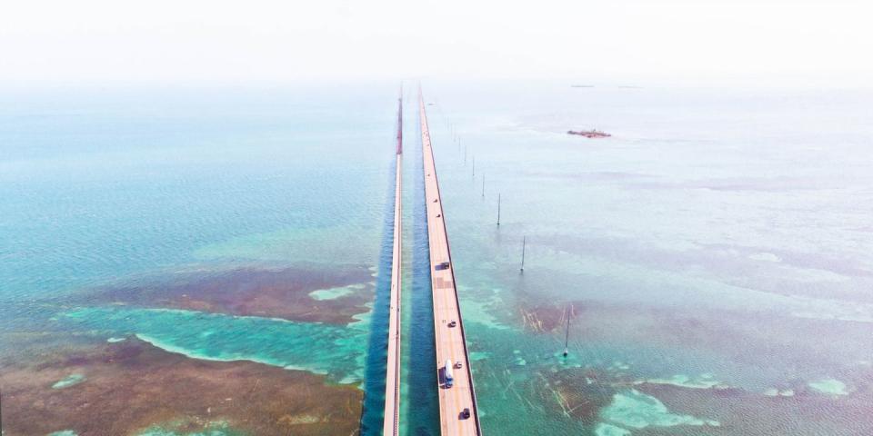 drone view of the overseas highway in florida keys with turquoise watercolor and infinite road