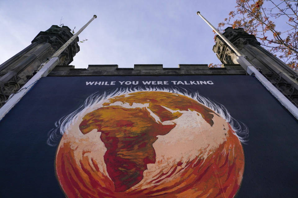 A panel depicting Planet Earth and a message reading 'While you were Talking', regarding the COP26 Summit is displayed on St John's Church, in Edinburgh, Scotland, Sunday, Nov. 7, 2021. (AP Photo/Alberto Pezzali)
