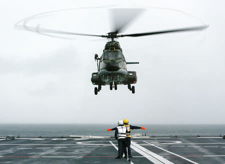 A Republic of Singapore Air Force Super Puma helicopter lands on the Singapore warship RSS Endurance during a search and rescue operation in the Singapore Strait, about 30 km (19 miles) east of the city state, on January 6, 2003. REUTERS/Jonathan Drake/File Photo