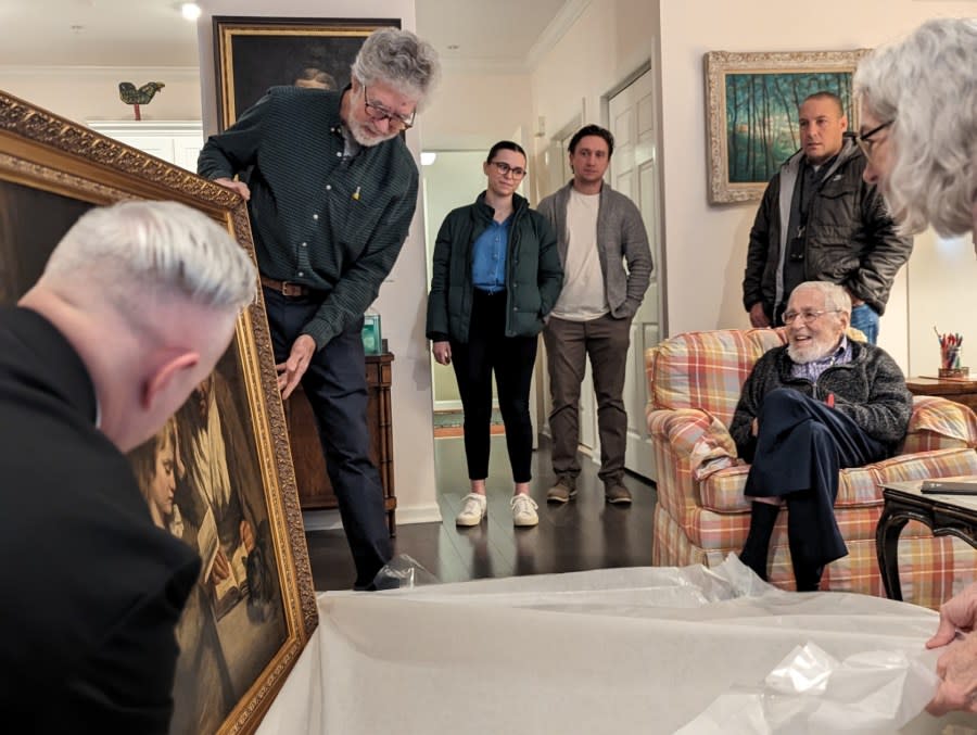 Siblings Tom Wood and Penelope Kulko assist Special Agent Gary France in unveiling the recovered painting to Dr. Francis Wood. (Courtesy: FBI)