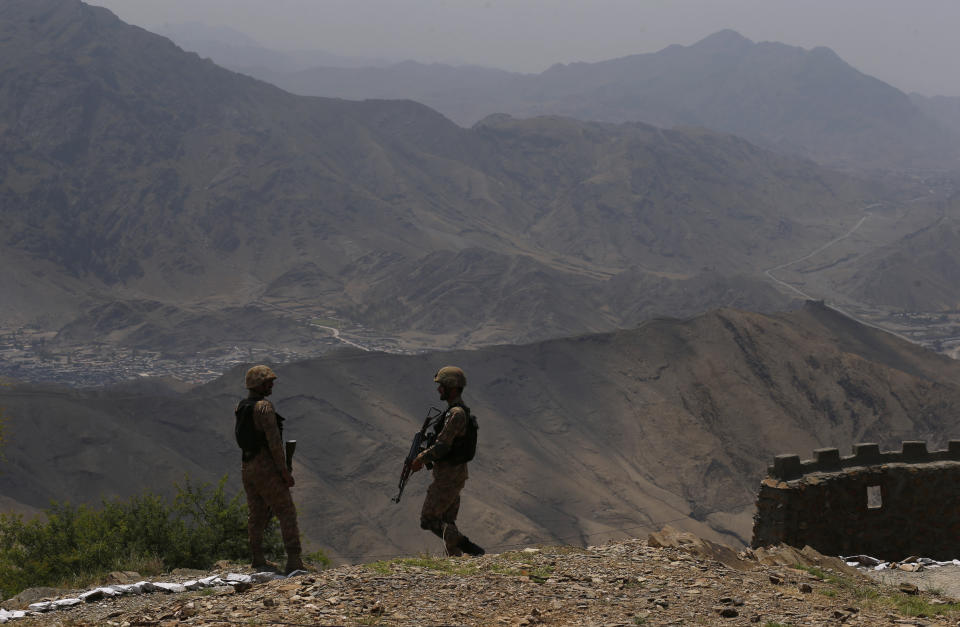 Pakistan Army troops observe the area from a hilltop post on the Pakistan Afghanistan border in Khyber district, Pakistan, Tuesday, Aug. 3, 2021. Pakistan's military said it completed 90 percent of the fencing along the border, vowing the remaining one of the most difficult tasks of improving the border management will be completed this summer to prevent any cross-border militant attack from both sides. (AP Photo/Anjum Naveed)