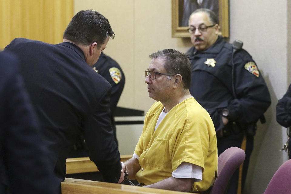 Paul Caneiro shakes hands with Michael Wicke, deputy assistant public defender, during his arraignment in the murders of his brother and his brother's family, before Judge Joseph W. Oxley at the Monmouth County Courthouse in Freehold, NJ Monday, March 18, 2019. (Tanya Breen/NJ Advance Media via AP, Pool)