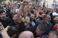 Supporters of the Shiite Hezbollah and Amal groups chant slogans during the funeral processions of Hassan Jamil Nehmeh, who was killed during Thursday clashes, in the southern Beirut suburb of Dahiyeh, Lebanon, Friday, Oct. 15, 2021. Dozens of gunmen opened fire in the air Friday south of Beirut during the funeral of persons killed in hours of gun battles between heavily armed gunmen the day before that left seven people dead and terrorized the residents of Beirut. (AP Photo/Bilal Hussein)