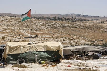 A general view shows a Palestinian flag and tents in Susiya village, south of the West Bank city of Hebron July 20, 2015. REUTERS/Mussa Qawasma