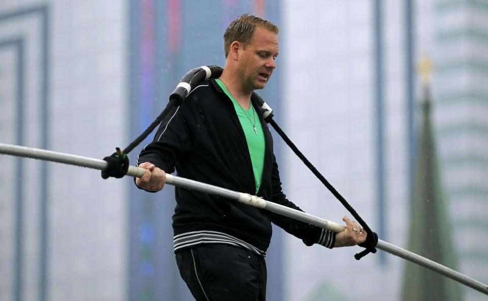 FILE - This May 16, 2012 photo shows Nik Wallenda performing a walk on a tightrope in the rain during training for his walk over Niagara Falls in Niagara Falls, N.Y. Wallenda can't visit a new place without envisioning a wire strung high above his head: Linking buildings, landmarks, nations. Even as a 6-year-old at Niagara Falls with his parents, he pictured walking a tightrope over the raging, whitewater maw. Now 33, he's ready to live out that childhood fantasy when he attempts Friday, June 15, 2012 to become the first person ever to walk a tightrope directly over the brink of Niagara Falls. (AP Photo/David Duprey)