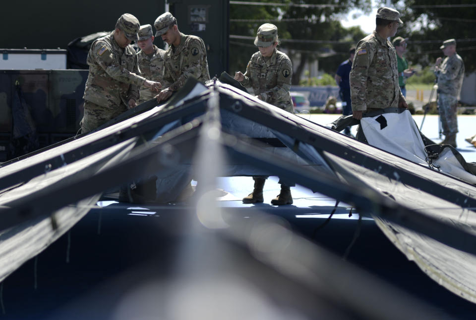 Members of the US army reserve set up tents for portable showers at a tent city set up to house hundreds of people displaced by earthquakes in Guanica, Puerto Rico, Tuesday, Jan. 14, 2020. More than 1,280 earthquakes have hit Puerto Rico’s southern region since Dec. 28, more than two dozen of them magnitude 4.5 or greater, according to the U.S. Geological Survey. (AP Photo/Carlos Giusti)