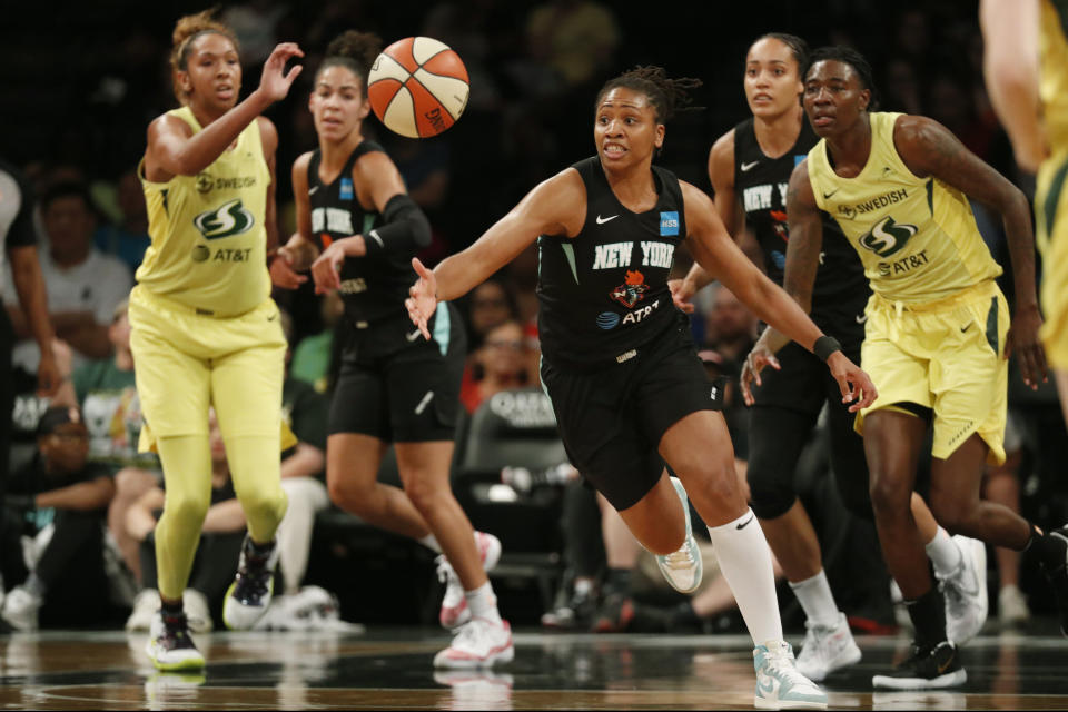 FILE - In this Aug. 11, 2019, file photo, New York Liberty guard Tanisha Wright, center, goes after a loose ball during the first half of the team's WNBA basketball game against the Seattle Storm at Barclays Center in New York. The Liberty will have a new home next year, playing their games at Barclays Center. Liberty team executives told the AP on Thursday that the franchise will play all its home contests at the Brooklyn arena that houses the Nets. The building was recently purchased by Liberty owner Joe Tsai, who also owns the Nets. Playing in Barclays Center is a huge upgrade for the Liberty, who played the past two seasons at the Westchester County Center, where the capacity was set for just over 2,000 fans. (AP Photo/Kathy Willens, File)