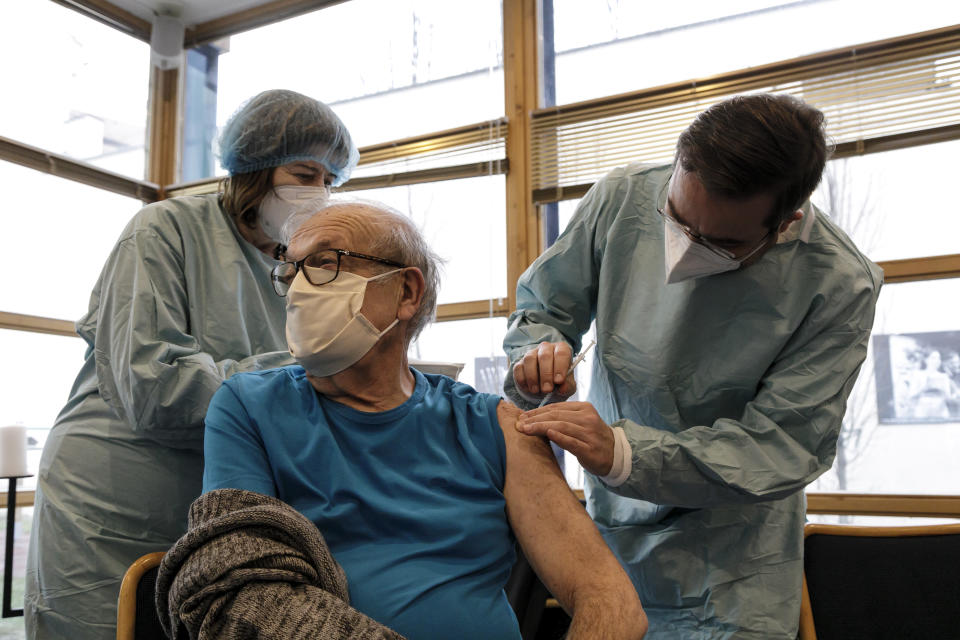 A Holocaust survivor receives the COVID-19 vaccine from Health Minister Marek Krajci, right, on International Holocaust Remembrance Day in Bratislava, Slovakia, Wednesday, Jan. 27, 2021. Hundreds of Holocaust survivors in Austria and Slovakia were poised to get their first coronavirus vaccinations, acknowledging their past suffering with a special tribute 76 years after the liberation of the Auschwitz death camp, where the Nazis killed more than 1 million Jews and others. (Dano Veselsky/TASR via AP)