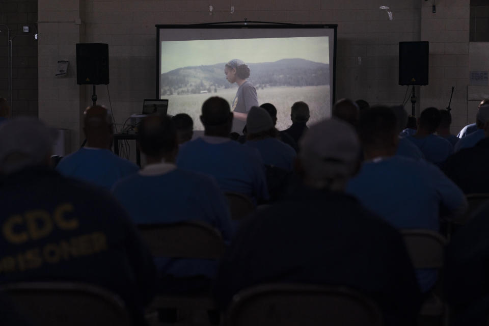 Prisoners watch a personal documentary film, "The Death of My Two Fathers," by director Sol Guy in the prison's gymnasium in Chowchilla, Calif., Friday, Nov. 4, 2022. The gym had been closed for recreational activities like basketball as part of ongoing COVID restrictions. About 150 prisoners were allowed in for the film – individual bags of buttered popcorn and cold beverages included with admission – their excitement palpable after many months of isolation. (AP Photo/Jae C. Hong)