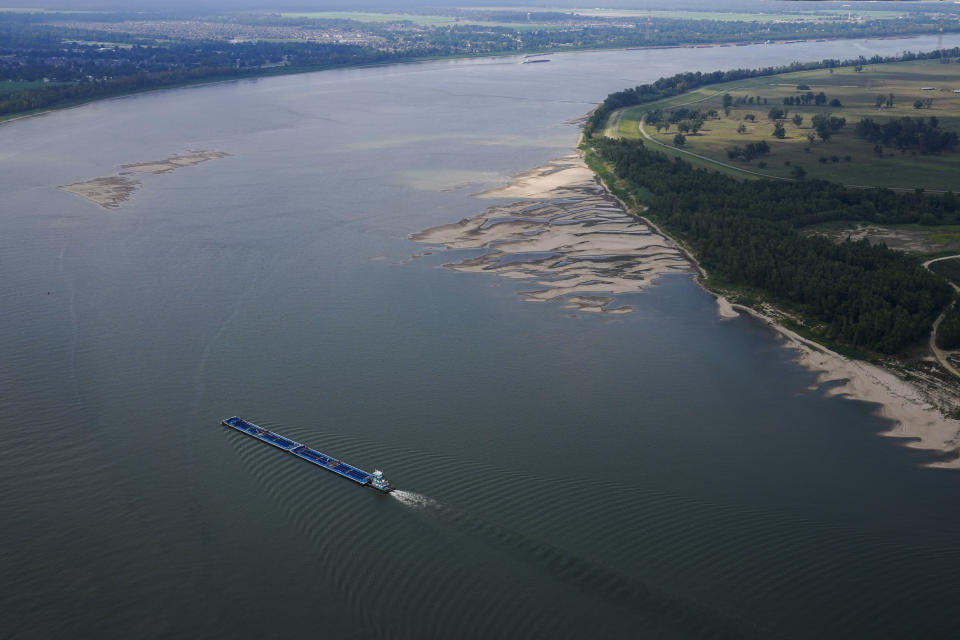 In this aerial photo, a tugboat pushing barges navigates between and around sandbars during low water levels on the Mississippi River between Baton Rouge, La., and Reserve, La., in Livingston Parish, La., Thursday, Sept. 14, 2023. (AP Photo/Gerald Herbert)