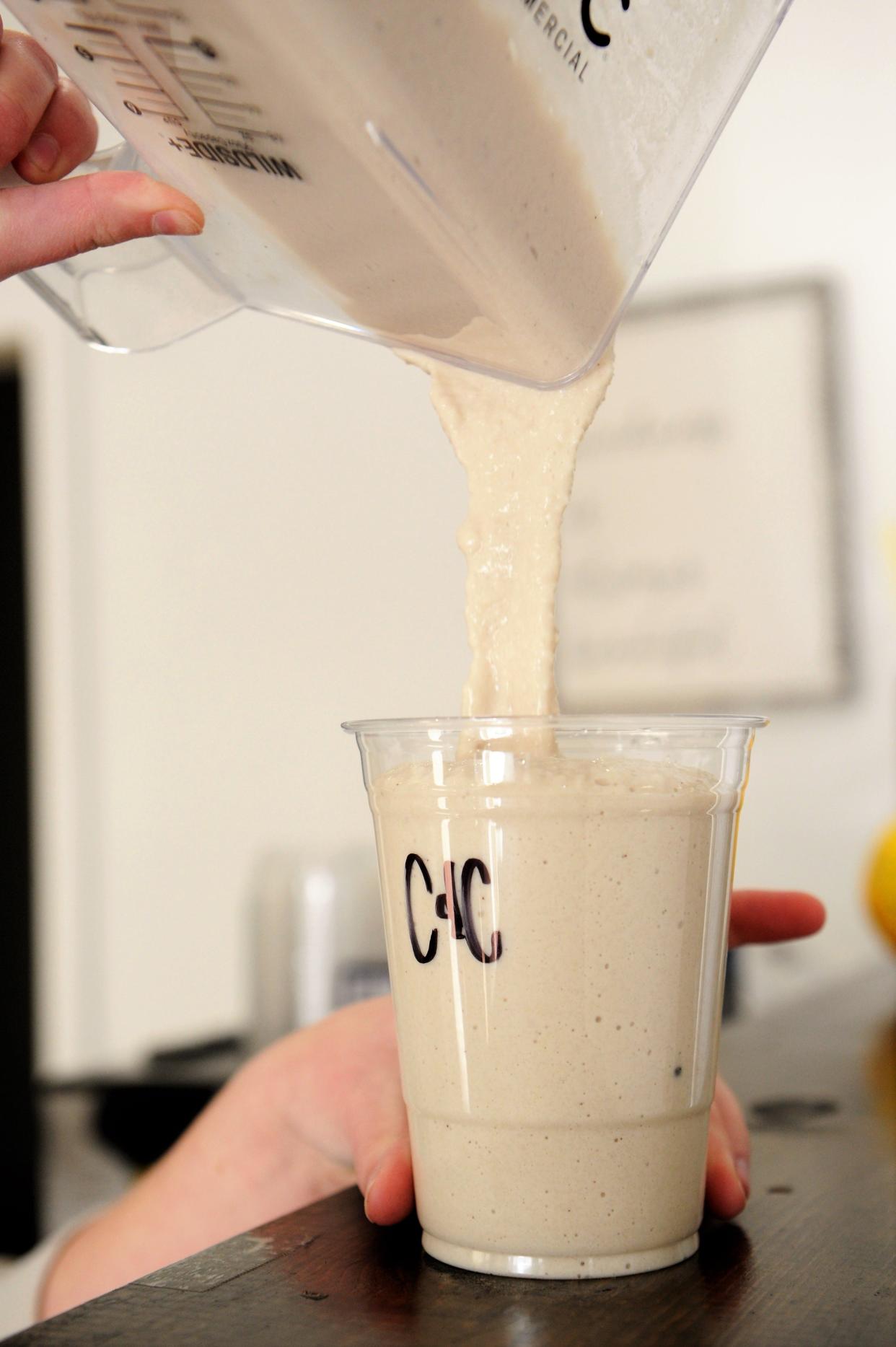 Alex Bullard pours a cookies and cream protein shake at Corner Nutrition on Saturday, Nov. 27, 2021.