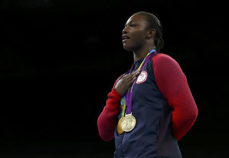 Rio Olympics - Boxing - Victory Ceremony - Women's Middle (75kg) Victory Ceremony - Riocentro - Pavilion 6 - Rio de Janeiro, Brazil - 21/08/2016. Gold medallist Claressa Shields (USA) of USA poses with her medals from London 2012 (purple) and Rio 2016 as she sings the national anthem. REUTERS/Peter Cziborra