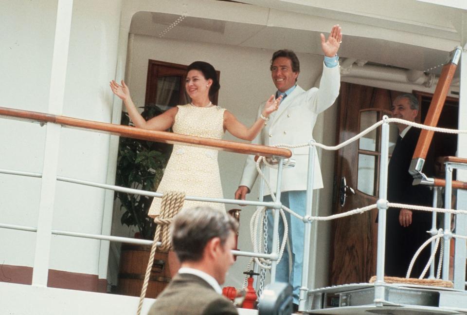 <p>Princess Margaret wears a pale yellow shift dress on the Royal Yacht Britannia. Her husband is dressed just as colorfully in a pair of pale blue pants, a blue shirt, and a white double-breasted blazer. </p>