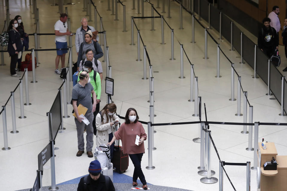 Fila de escasos pasajeros en el aeropuerto Seattle-Tacoma el15 de abril de 2020(AP /Elaine Thompson)