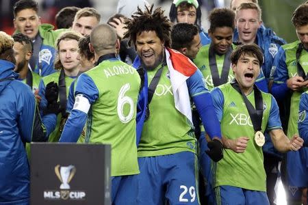 Dec 10, 2016; Toronto, Canada; Seattle Sounders defender Roman Torres (29) is greeted by midfielder Osvaldo Alonso (6) on the podium after defeating Toronto FC in the 2016 MLS Cup at BMO Field. Mandatory Credit: Geoff Burke-USA TODAY Sports