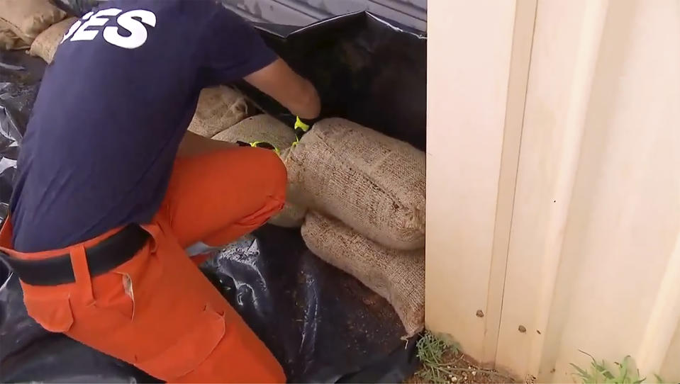 This image made from a video, shows State Emergency Services (SES) workers sandbagging in Port Hedland, Australia Wednesday, April 12, 2023. Miners, cattle ranchers, tourists and Indigenous locals were evacuating from Australia’s remote northwest coast on Wednesday as an intensifying tropical cyclone approached. (Australian Broadcasting Corporation via AP)