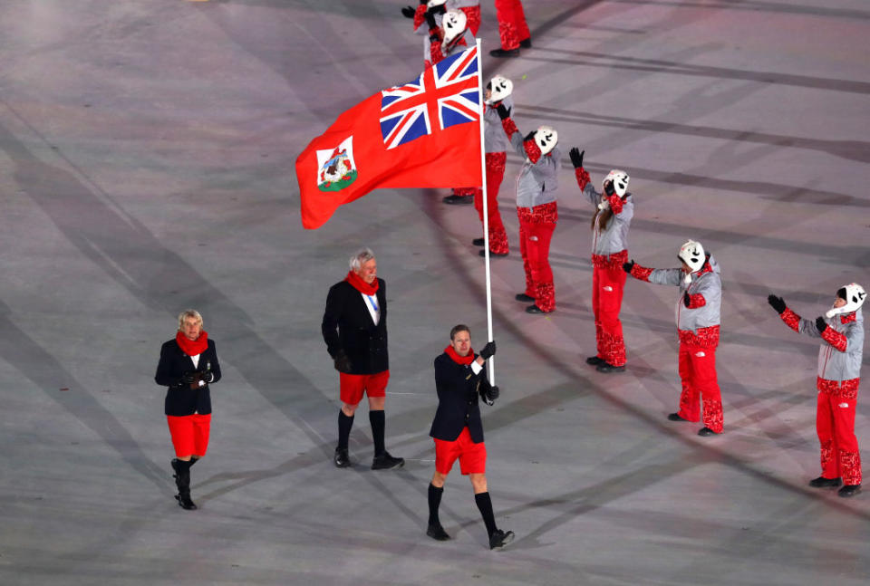 <p>Flag bearer Tucker Murphy of Bermuda and teammates wear navy blazers, red shorts, matching scarves, and knee-high socks when entering the stadium during the opening ceremony of the 2018 PyeongChang Games. (Photo: Dean Mouhtaropoulos/Getty Images) </p>