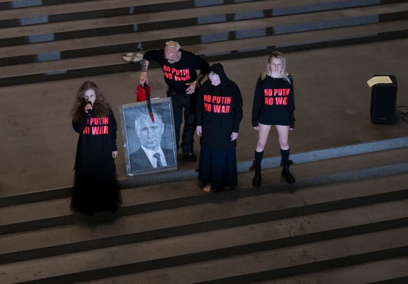 Austrian artist Wolfgang Flatz (2nd L) and three members of the Russian band Pussy Riot perform music and actions as part of the Flatz retrospective at the Pinakothek der Moderne Art museum in Munich. Peter Kneffel/dpa