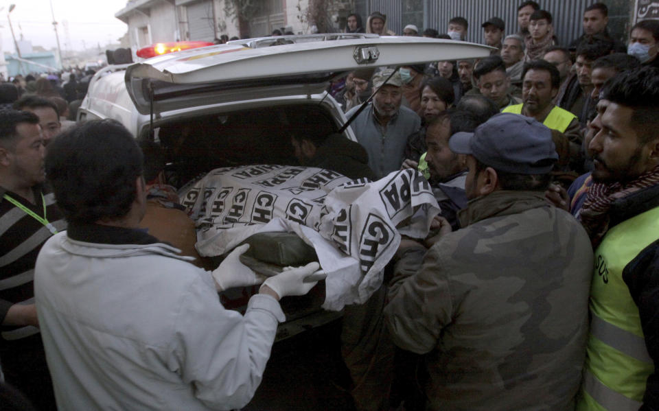 People from the Shiite Hazara community unload the body of a coal mine worker who with others were killed by unknown gunmen near the Machh coal field, in Quetta, Pakistan, Sunday, Jan. 3, 2021. Gunmen opened fire on a group of minority Shiite Hazara coal miners after abducting them, killing 11 in southwestern Baluchistan province early Sunday, a Pakistani official said. (AP Photo/Arshad Butt)