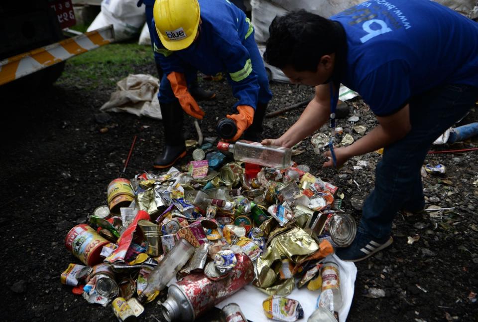 Trabajadores buscan materiales reciclables entre un montón de residuos recolectados en el monte Éverest (Nepal) en 2019 (AFP via Getty Images)