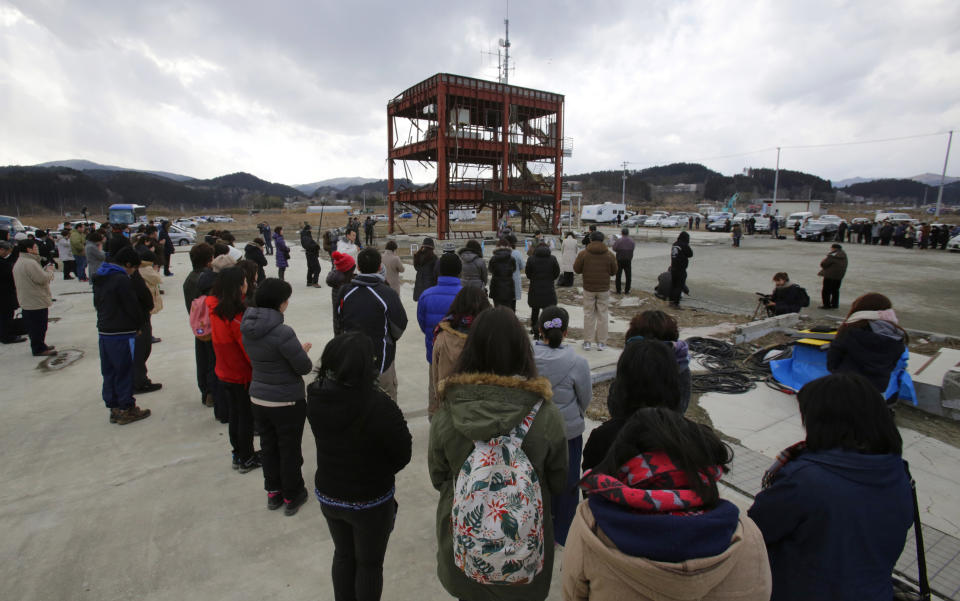 Gathering around what is left of a disaster control center devastated by the March 11, 2011 earthquake and tsunami, people bow their heads Tuesday, March 11, 2014 in Minamisanriku, Miyagi prefecture in a moment of silence at 2:46 p.m. when the magnitude 9.0 earthquake struck off Japan's northeastern coast. Japan marked the third anniversary on Tuesday of a devastating disasters that left nearly 19,000 people dead or missing. (AP Photo/Shizuo Kambayashi)