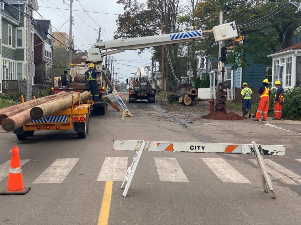 Maritime Electric has identified 504 power poles as damaged. This crew was putting up new poles in Charlottetown Wednesday. (Kirk Pennell/CBC - image credit)