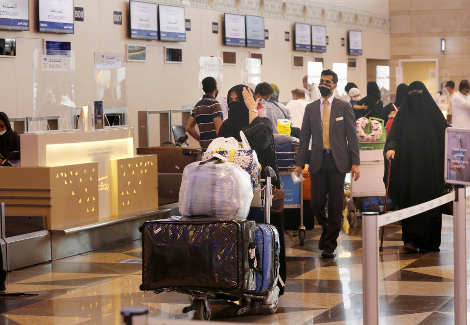 Saudi passengers prepare to check-in for flights at the King Abdulaziz International Airport in Jiddah, Saudi Arabia, Monday, May 17, 2021. Vaccinated Saudis will be allowed to leave the kingdom for the first time in more than a year as the country eases a ban on international travel that had been in place to try and contain the spread of the coronavirus and its new variants. (AP Photo/Amr Nabil)