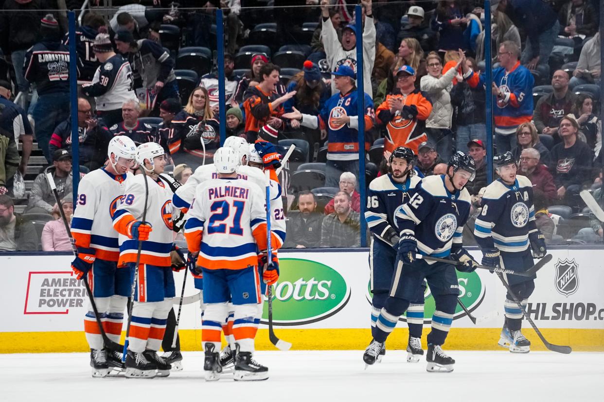 Apr 4, 2024; Columbus, Ohio, USA; The Columbus Blue Jackets skate off the ice as the New York Islanders celebrate their 4-2 win following the NHL hockey game at Nationwide Arena.