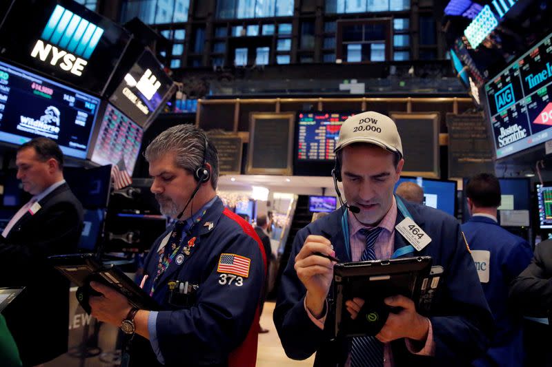 FILE PHOTO: Traders work on the floor at the New York Stock Exchange (NYSE) in Manhattan, New York City, U.S.