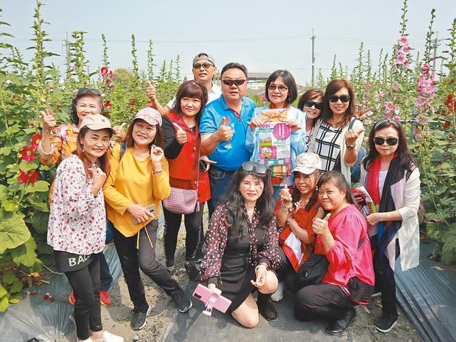 員林蜀葵花季活動今年邁入第七年，首度移師至西區大埔里運動公園旁農田辦理，19日開園首日就迎來宜蘭的遊覽車團客，眾人爭相拍照，員林市長游振雄（中）熱情接待這群遊客。（謝瓊雲攝）