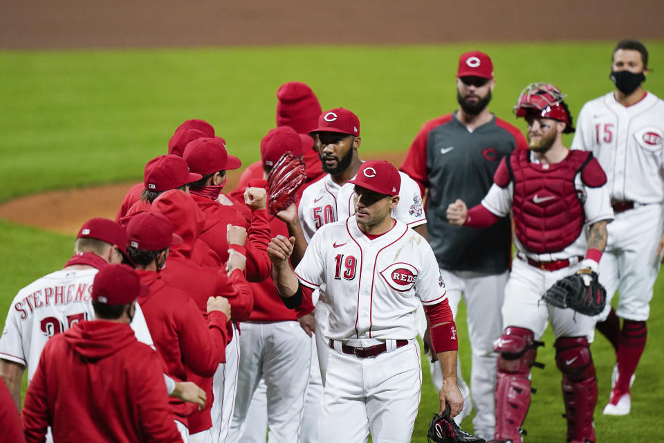 Cincinnati Reds celebrate after defeating the Pittsburgh Pirates 4-1 in a baseball game in Cincinnati, Tuesday, Sept. 15, 2020. (AP Photo/Bryan Woolston)