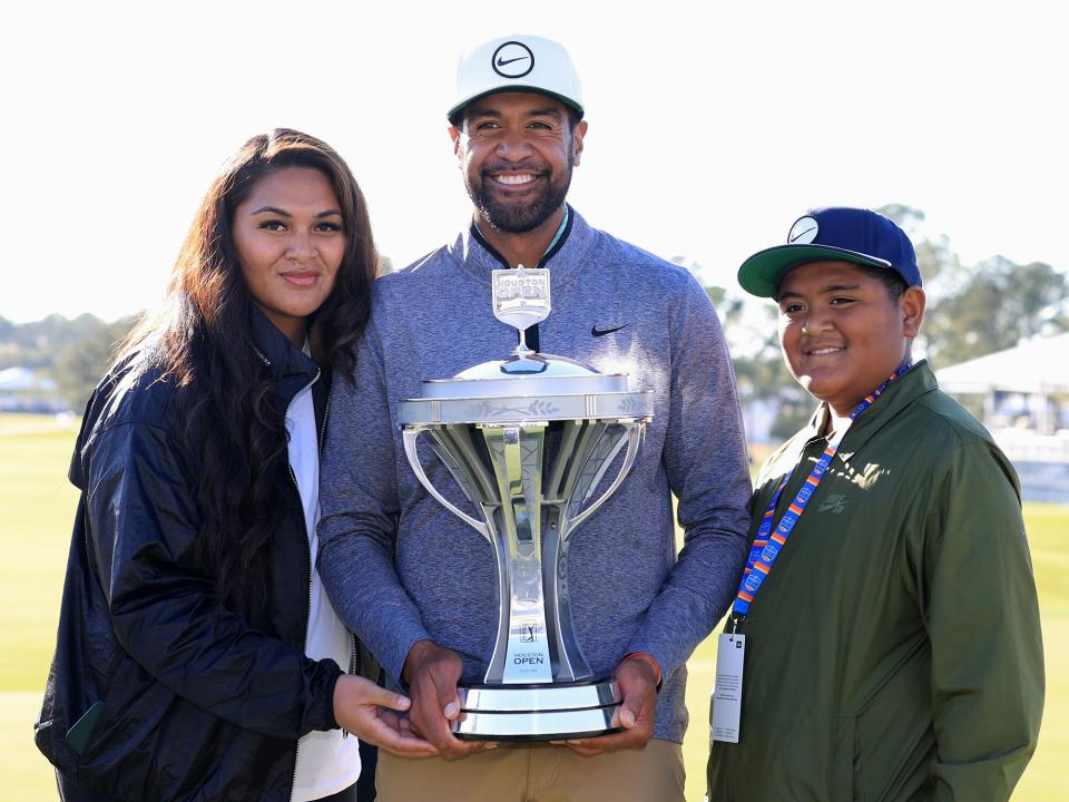 Tony Finau of the United States poses with the trophy and his wife Alayna and son Drace after putting in to win on the 18th hole during the final round of the Cadence Bank Houston Open at Memorial Park Golf Course on November 13, 2022 in Houston, Texas