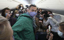 FILE - In this Jan. 17, 2021, file photo, Alexei Navalny is surrounded by journalists inside the plane prior to his flight to Moscow in the Airport Berlin Brandenburg (BER) in Schoenefeld, near Berlin, Germany. The return of Navalny from Germany after he spent five months in Berlin recovering from a nerve agent poisoning was marked by chaos and popular outrage, and it ended, almost predictably with his arrest. The Jan. 17 flight carried him and his wife, along with a group of journalists documenting the journey. (AP Photo/Mstyslav Chernov, File)