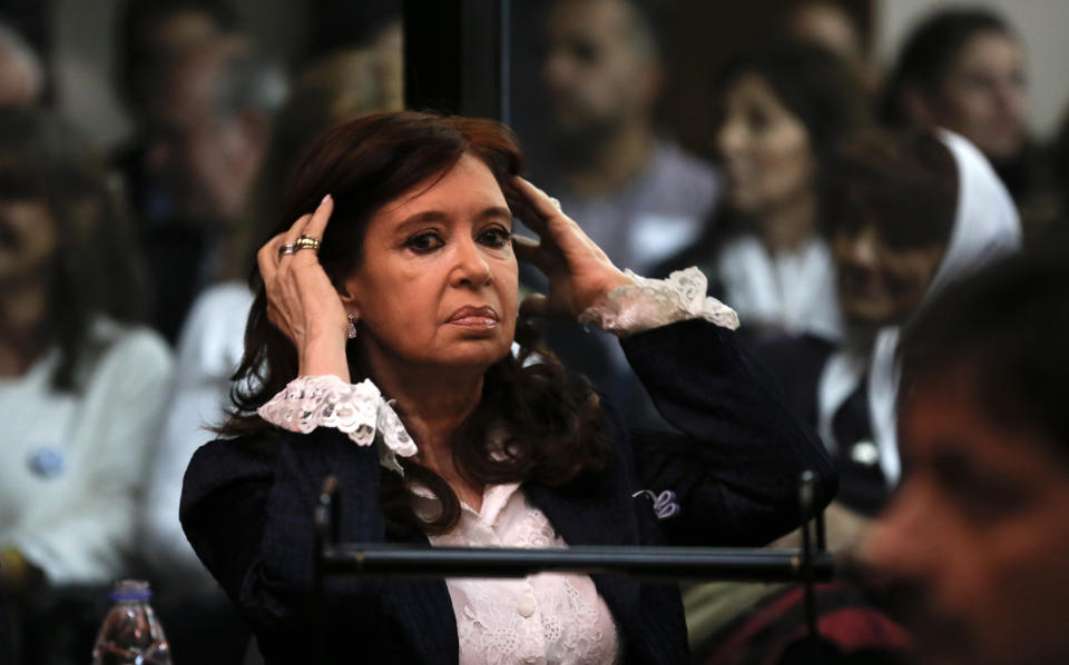 Former President Cristina Fernandez pushes her back while sitting inside a federal courtroom, in Buenos Aires, Argentina, Tuesday, May 21, 2019. Fernandez is in court for the first in a series of corruption trials. (AP Photo/Marcos Brindicci)