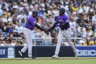 Colorado Rockies' German Marquez celebrates with third base coach Stu Cole after hitting a home run against the San Diego Padres during the fifth inning of a baseball game Saturday, July 31, 2021, in San Diego. (AP Photo/Derrick Tuskan)