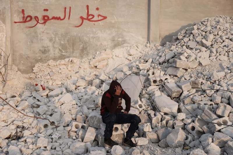 Fears are growing about the burden on young people after the disaster. Muhammad Al-Mula, 15, sits near his destroyed house as a result of the deadly earthquake along the Turkish-Syrian border. Anas Alkharboutli/dpa