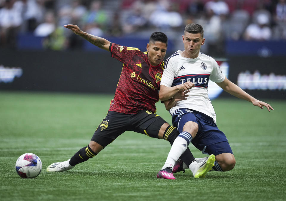 Vancouver Whitecaps' Ranko Veselinovic, right, stops a pass intended for Seattle Sounders' Raul Ruidiaz during the first half of an MLS soccer match Saturday, July 8, 2023, in Vancouver, British Columbia. (Darryl Dyck/The Canadian Press via AP)