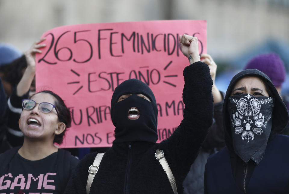 Women shout during a protest against gender violence outside the National Palace that includes the presidential office and residence, in Mexico City, Tuesday, Feb. 18, 2020. The killing of a 7-year-old girl on the southern outskirts of Mexico City has stoked rising anger over the brutal slayings of women, including one found stabbed to death and skinned earlier this month. (AP Photo/Eduardo Verdugo)