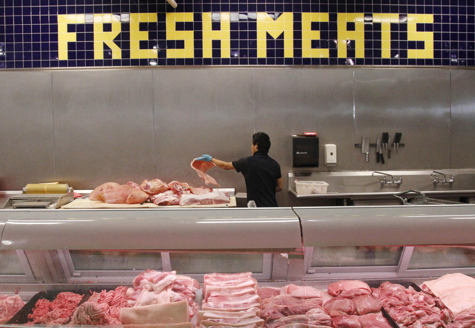 Butcher Freddie Quina cuts meat at Super Cao Nguyen in Oklahoma City, Wednesday, July 25, 2012. The record drought gripping half the country will help push food prices up by 3 percent to 4 percent next year, the U.S. Department of Agriculture said. (AP Photo/Sue Ogrocki)